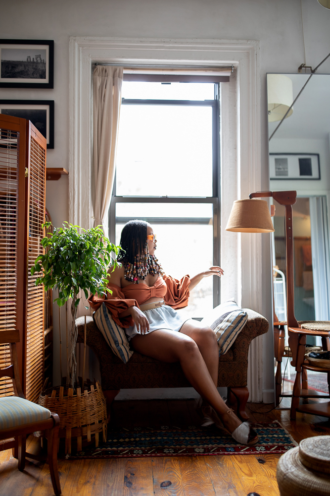 Woman with beads looking outside of the window