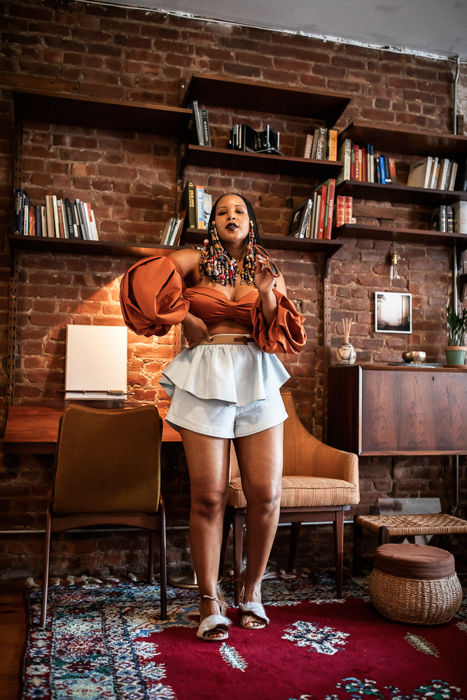 Woman with Beads and Braids Wearing Fe Noel Rust Puff Sleeve Bodysuit