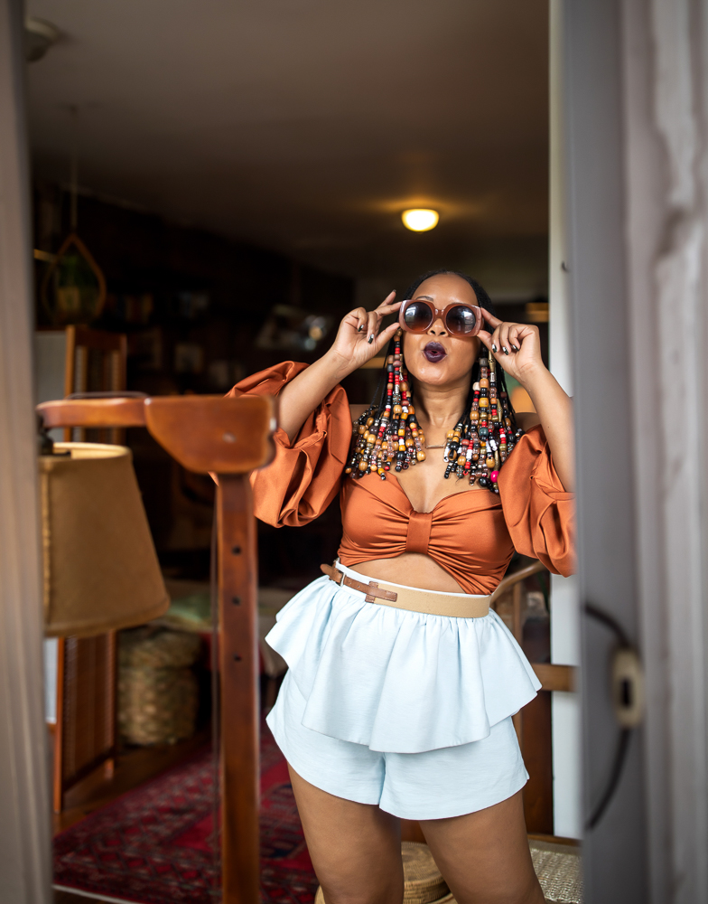 Woman with Beads and Braids Wearing Fe Noel Rust Puff Sleeve Bodysuit